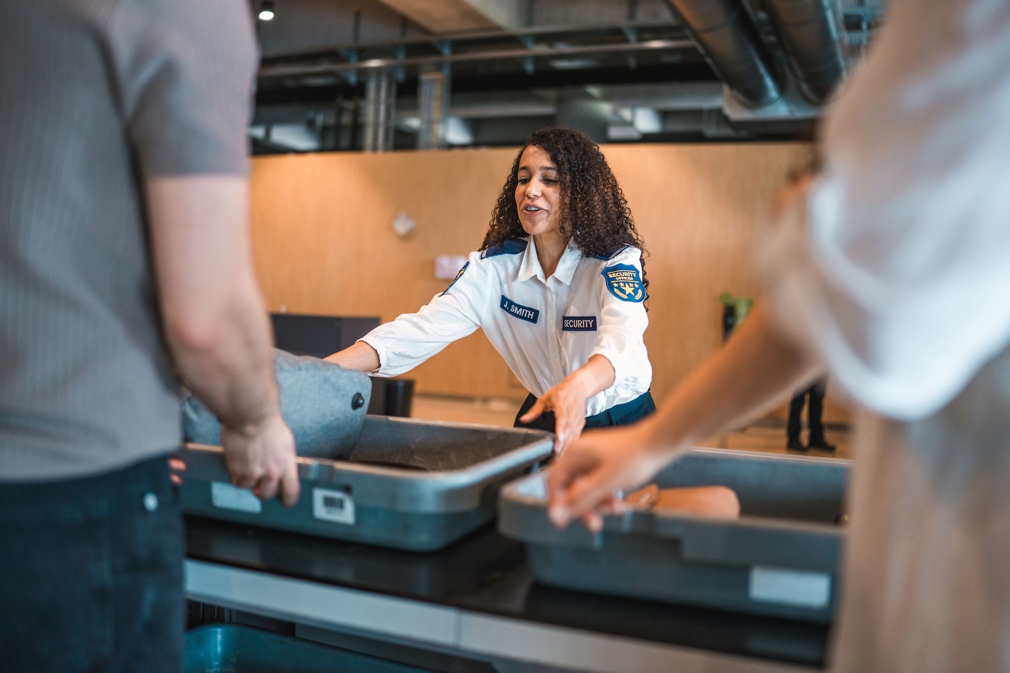 TSA Officer Moves a Tray at Airport Security